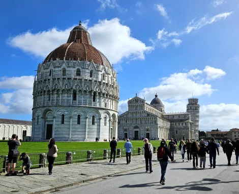 a group of people walking in front of a large building with Piazza dei Miracoli in the background
